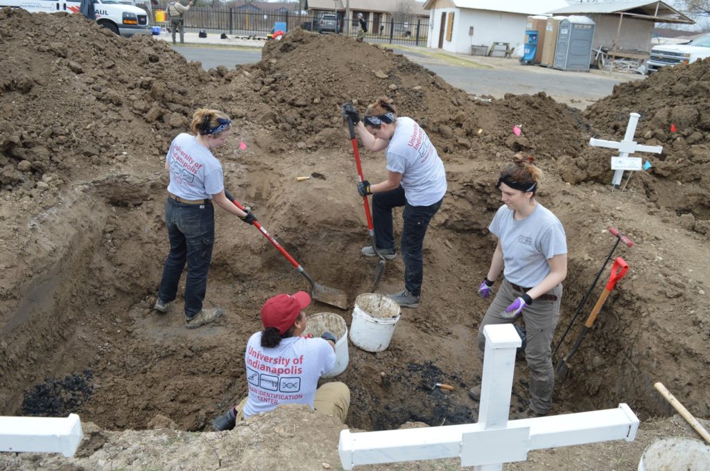 Team members digging at the cemetery