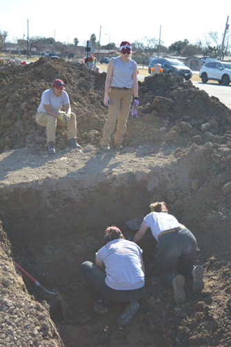 Team members removing dirt from a burial