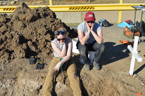 Two team members taking a break and watching others work at the cemetery 