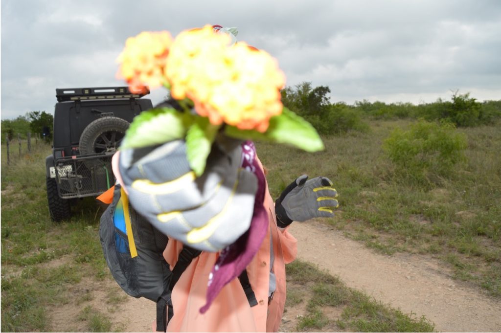 A team member holding up a flower to the camera