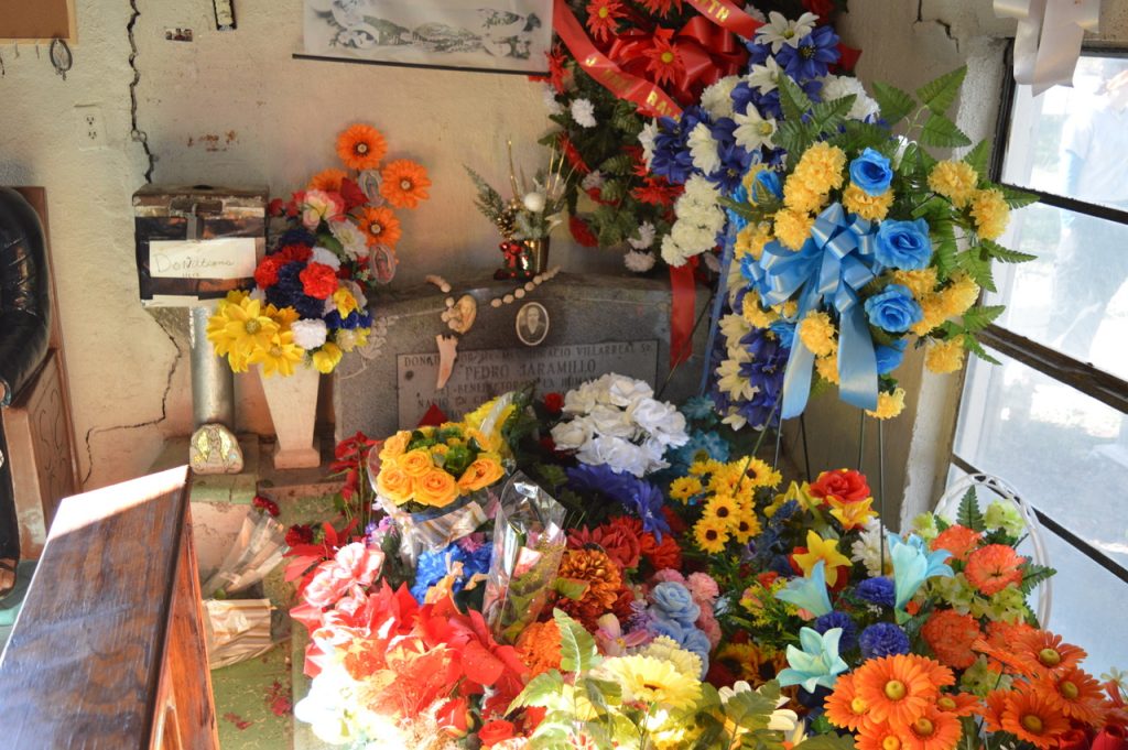 Don Pedrito headstone covered in decorations and flowers. 