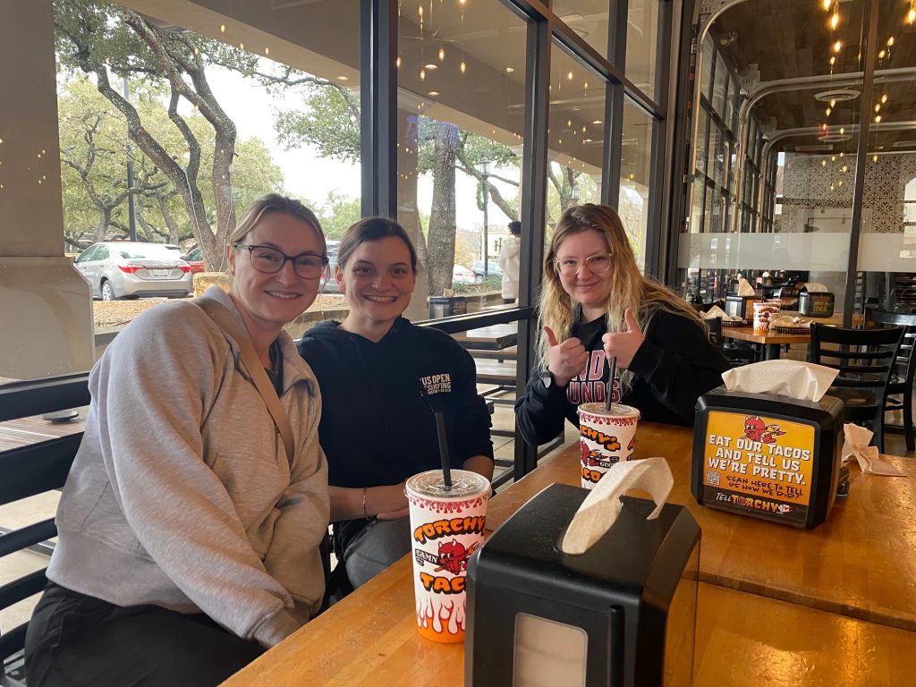 Hannah, Claire, and Chastidy smile as they wait for their lunch in San Antonio