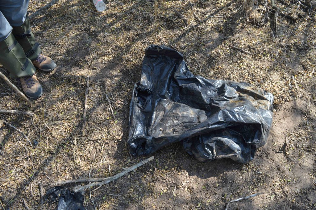 Trash bag that has head and arm holes cut into it so it could be used as covering