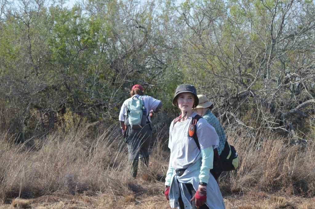 Some team members lined up in the brush.