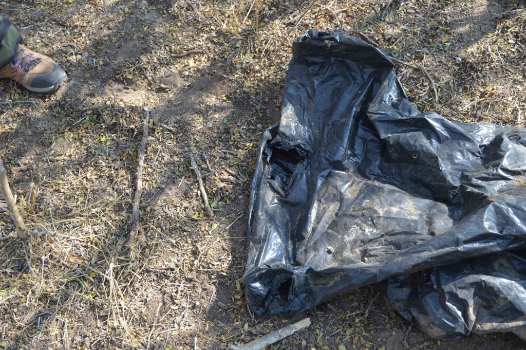 Trash bag found in layup with a hole in it to place one's head and two arms to place one's arms